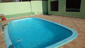 a large blue swimming pool in a yard at casa verde hospedaria in Goiás +2 photos