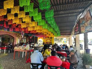 a group of people sitting at tables in a restaurant at Hotel Leilani in San Andrés Sinaxtla +12 photos