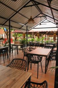 an outdoor patio with tables and chairs and awnings at Hotel Campestre Villa Ocha in Valledupar