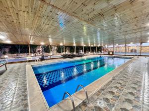a large swimming pool with blue water at شاليه و مزرعة ادم in Rujm as Sab‘