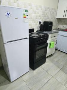 a kitchen with a white refrigerator and a stove at Peshline Guest House Unit 3 in Ermelo +5 photos