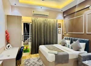 a bedroom with a bed and a desk and a window at Private Cinema Apartment By Buddies Home in Greater Noida +27 photos
