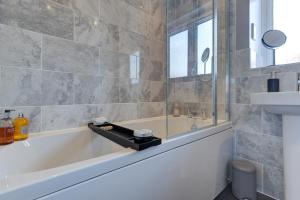 a bathroom with a tub and a sink at Marriott House sleeps 5 in Bourne with parking in Bourne
