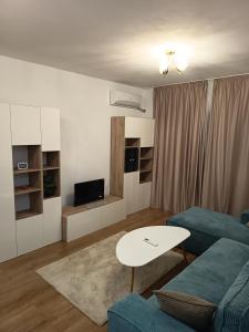 a living room with a couch and a table at Family's delight in Giroc
