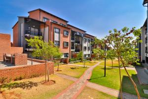 an image of an apartment complex with trees in a park at Waterfall Ridge Luxurious Apartments - Backup Power! in Midrand