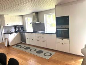 Una cocina con gabinetes blancos y una ventana grande. en 4 star holiday home in SÖLVESBORG, en Falkvik 22 fotos más