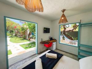 a bedroom with a bed and a desk and a window at Casa Peroá Pousada in Icaraí