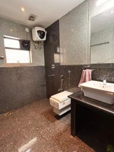 a bathroom with a sink and a toilet and a mirror at Alaansh Villa Perfect Backyard & BBQ Retreat in Assagao