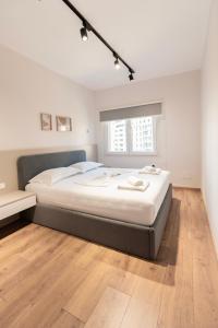 a large bed in a bedroom with a wooden floor at 2BR at Artist's Palace - Skanderbeg Square Views in Tirana
