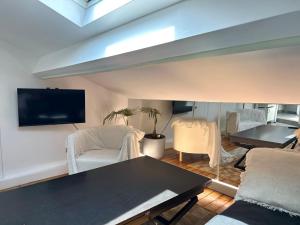 a living room with a table and chairs and a tv at Charmant appartement vincennes in Vincennes