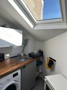 a kitchen with a sink and a washing machine at Charmant appartement vincennes in Vincennes +3 photos