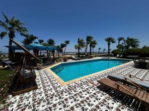 a swimming pool with chairs and a gazebo at apartment on the beach inside a hotel in Sharm El Sheikh