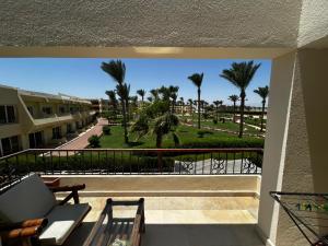 a balcony with a view of a park and palm trees at apartment on the beach inside a hotel in Sharm El Sheikh