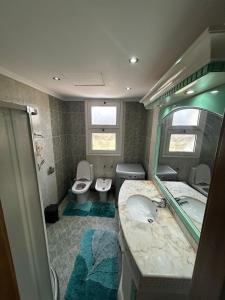 a bathroom with two toilets and a sink and a mirror at apartment on the beach inside a hotel in Sharm El Sheikh
