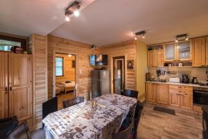 eine Küche mit Holzschränken und einem Tisch im Zimmer in der Unterkunft Villa Margarita 1 in Belitsa