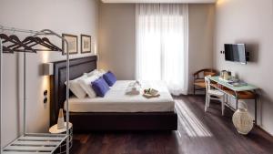 a hotel room with a bed and a desk and a bed at Al Sale in Cagliari