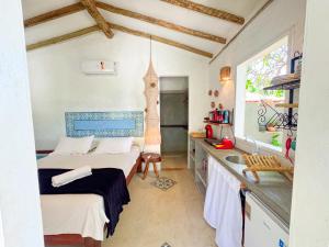 a small room with two beds and a sink at Casa Peroá Pousada in Icaraí