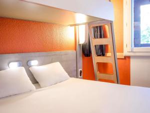 a bedroom with a bed with white pillows and a ladder at Ibis Budget Marseille Timone in Marseille