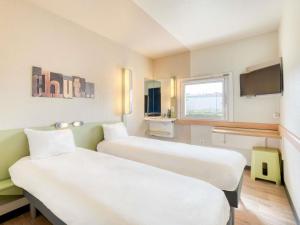 a hospital room with two beds and a tv at ibis budget Versailles - Trappes in Trappes