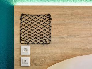 une grille métallique sur un mur avec deux sorties dans l'établissement HotelF1 Paris Saint Ouen Marché Aux Puces, à Paris