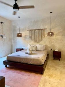 a bedroom with a large bed with two lights at The Heart of the City Room 3 in Mérida