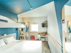 a small room with a bed and a desk at ibis budget Bourges in Bourges