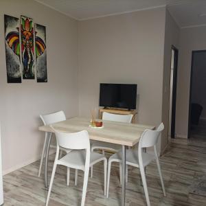 a dining room with a table and white chairs at El Refugio Tapalque in Tapalqué