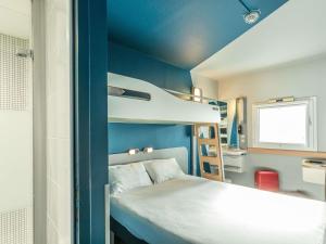 a small room with a bed and a bunk bed at ibis budget Bourges in Bourges +27 photos