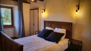 a bedroom with a bed with two pillows on it at La casa del jardì - Jardin clos, WIFI, authentique in Angoustrine