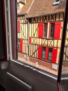 a window view of a building with red windows at Studio hyper centre de Beauvais in Beauvais