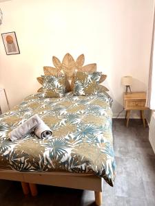 een bed met een deken en kussens erop bij Studio hyper centre de Beauvais in Beauvais