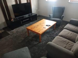 a living room with a coffee table and a television at Aureus Fons, Ganzes Haus, Altstadt 160 m, 24h Selbst-Check-in, Wi-Fi in Höchstadt an der Aisch