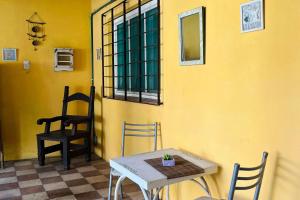 a table and chairs in a room with a yellow wall at HOSPEDAJE "La Catalina" Ubicada a 15 minutos del Aeropuerto de Ezeiza con Estacionamiento Gratis-Cancelacion Gratis -Desayuno Gratis -Parking Gratis-Se Paga al Ingresar in Tristán Suárez +3 photos