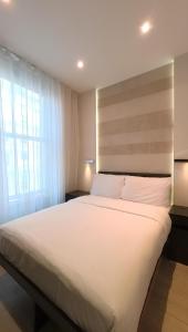 a large white bed in a room with a window at 39 Studios in London