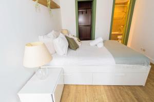 een wit bed in een kamer met een lamp bij Casa JOY in Casablanca