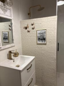 a bathroom with a sink and a white brick wall at Casa 1931 Breakfast Gratis in Valladolid