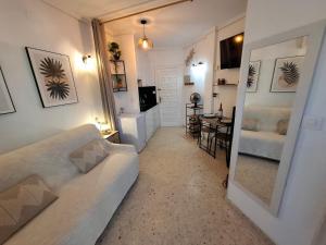 a living room with a white couch and a mirror at RETIRO V - Los Quesitos in Denia