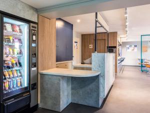 a kitchen with a counter and a refrigerator at Ibis Budget Villefranche in Limas