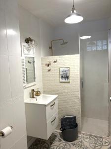 a white bathroom with a sink and a shower at Casa 1931 Breakfast Gratis in Valladolid
