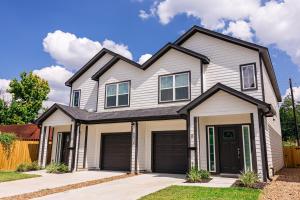 a white house with a black roof at Luxury 3BR Getaway Near Downtown - Med Center - NRG - Enjoy Smart TVs - Fast WiFi - Private Backyard in Houston