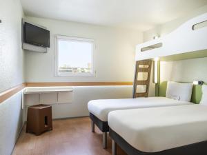 Una habitación de hotel con dos camas y un televisor. en ibis budget Paris Porte de Bercy, en Charenton-le-Pont