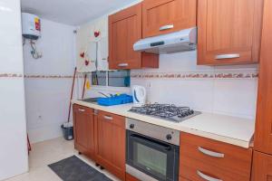 a kitchen with wooden cabinets and a stove top oven at Chã de Areia Lounge Vista Mar - Apartamento T2 in Praia +9 photos