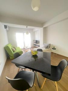 オフリドにあるStefea Center Apartment - Free Garage - Centralの黒いテーブルと椅子のあるリビングルーム