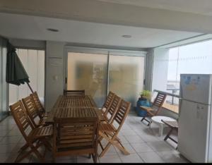 a room with a table and chairs and a refrigerator at bedroom living room gym security in Rosario
