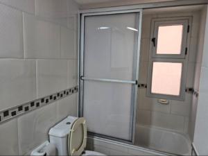 a bathroom with a shower and a toilet and a window at bedroom living room gym security in Rosario