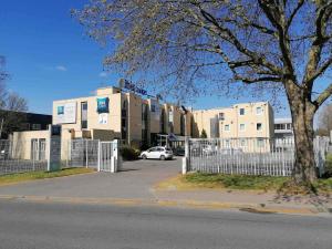 Un coche blanco aparcado delante de un edificio en ibis budget Antony Massy rénové 2024, en Antony