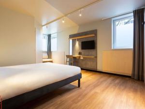 a room with a bed and a desk and a tv at ibis budget Antony Massy rénové 2024 in Antony