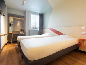 a room with three beds and a desk in it at ibis budget Antony Massy rénové 2024 in Antony
