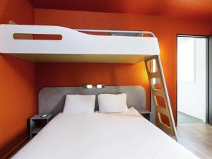 a bedroom with a bunk bed with an orange wall at ibis budget Paris Porte de Vincennes in Paris +37 photos