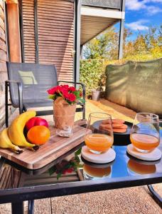 蒙泰夫兰Suite Oceïna Proche Disneyland Parking 4 Pers的露台上的桌子上摆放着水果和果汁